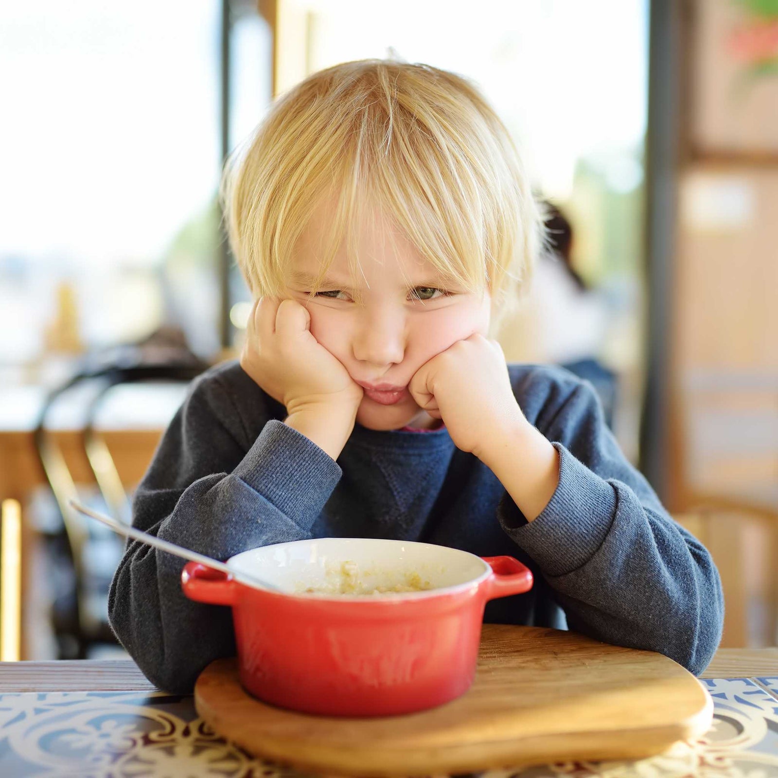 girl frowning up at her bowl of food