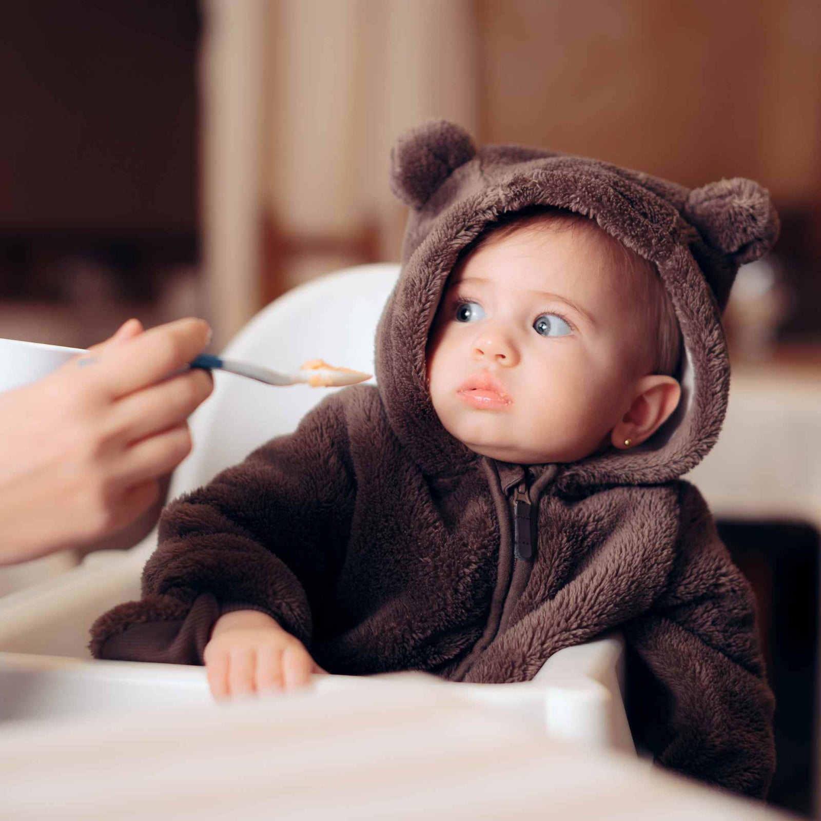 child being spoon-fed but refusing to eat