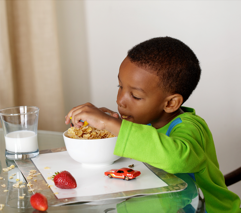 kid eating cereal at breakfast table - Easy Peasie Veggie Blends blog