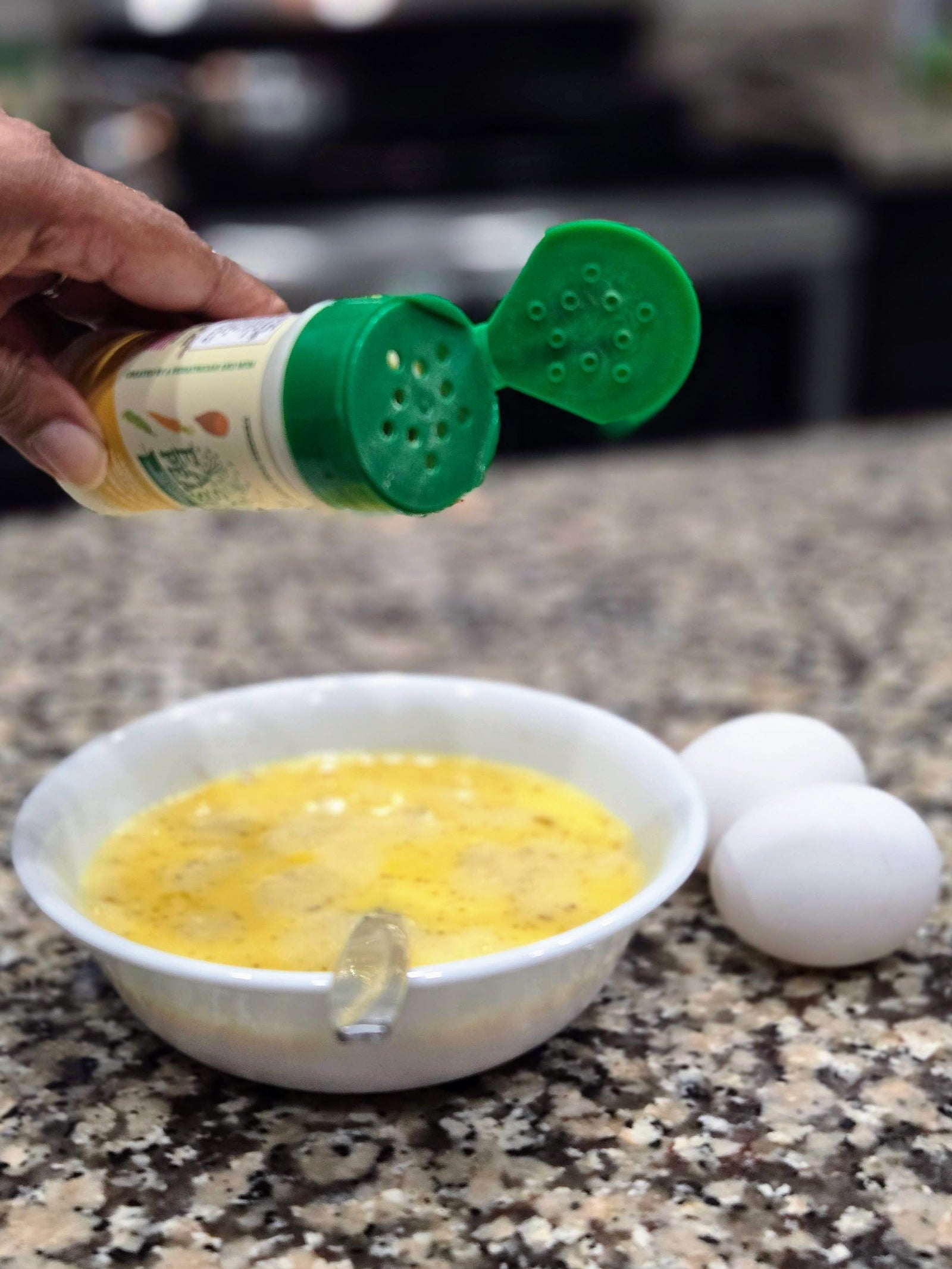 Sprinkling Easy Peasie Veggie Powder into scrambled eggs