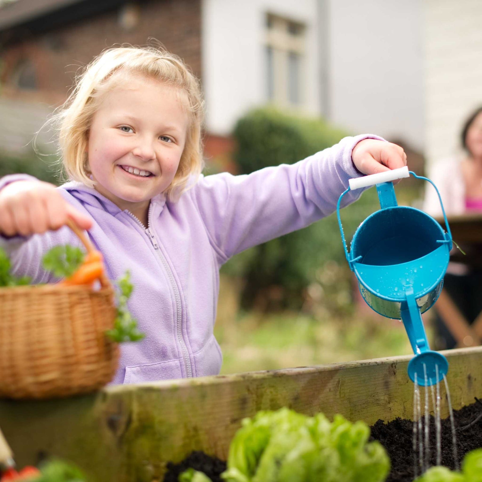 girl watering plants in garden