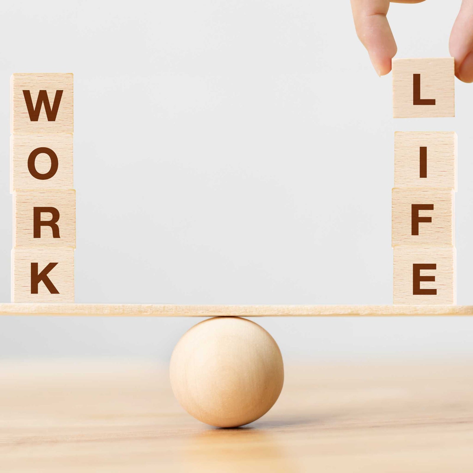 blocks spelling "work" and "life" on a balance scale