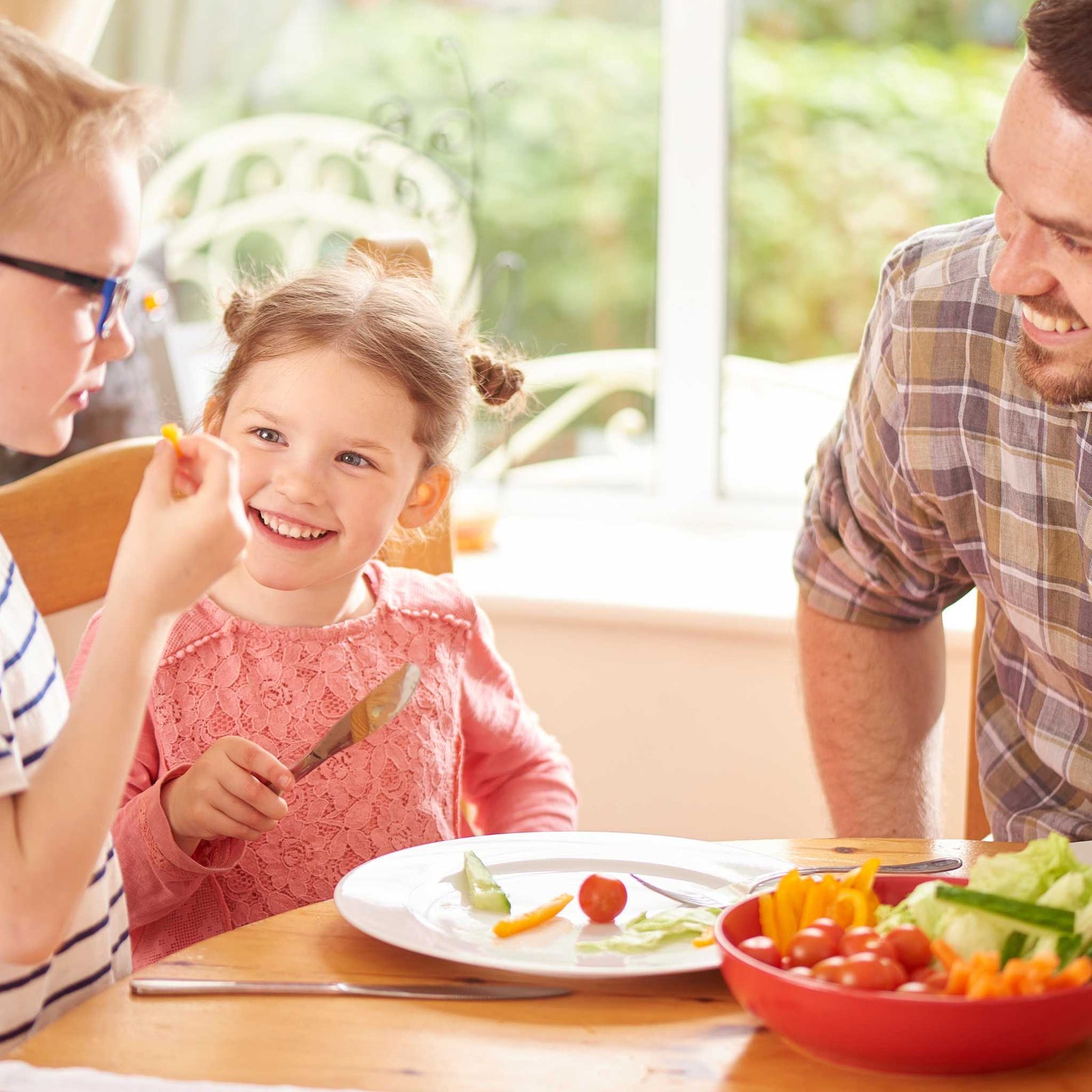 dad and kids eating vegetables