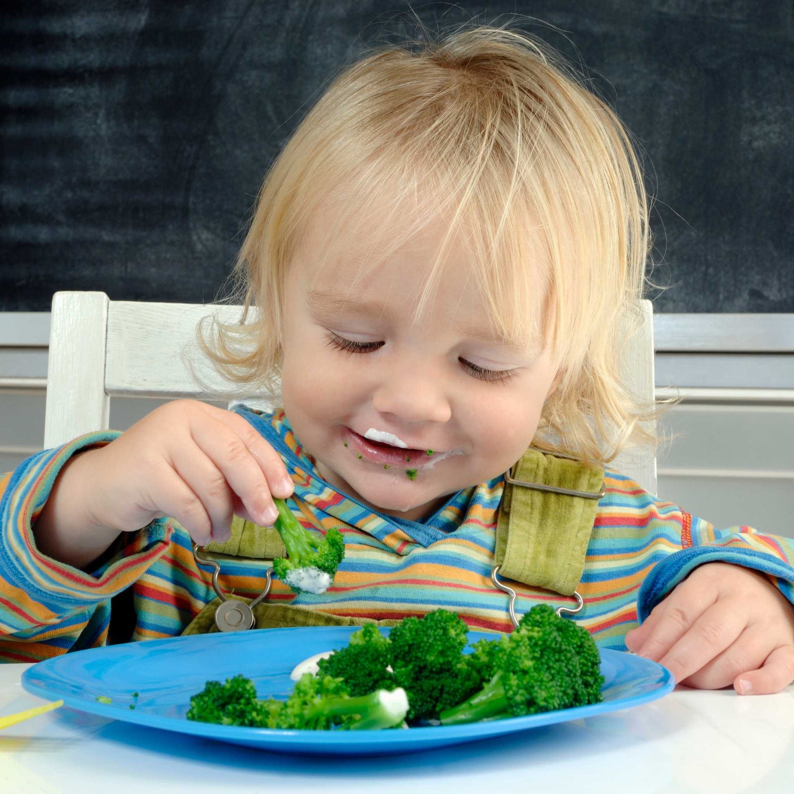 kid eating from a plate of broccoli