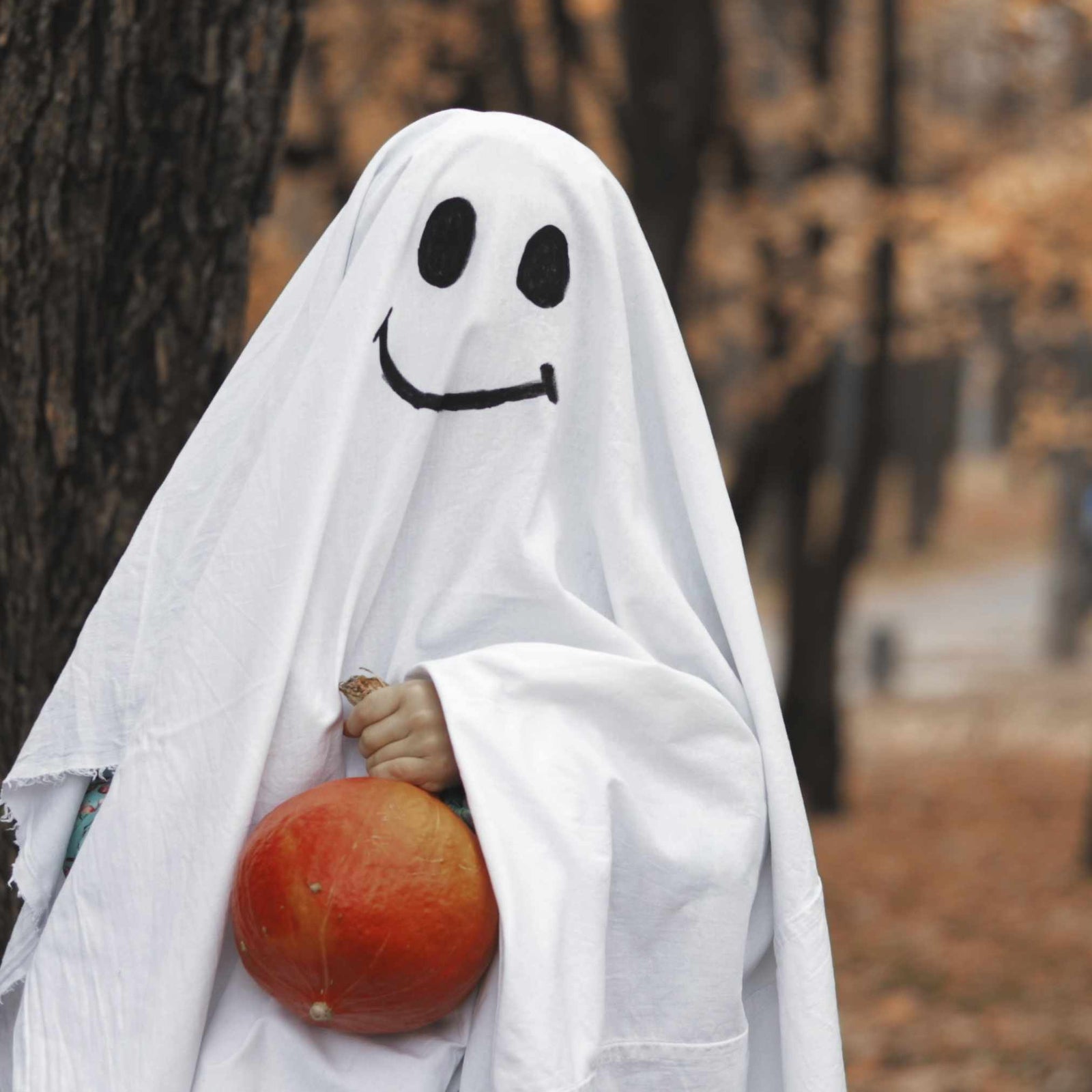 kid dressed up in smiling ghost costume