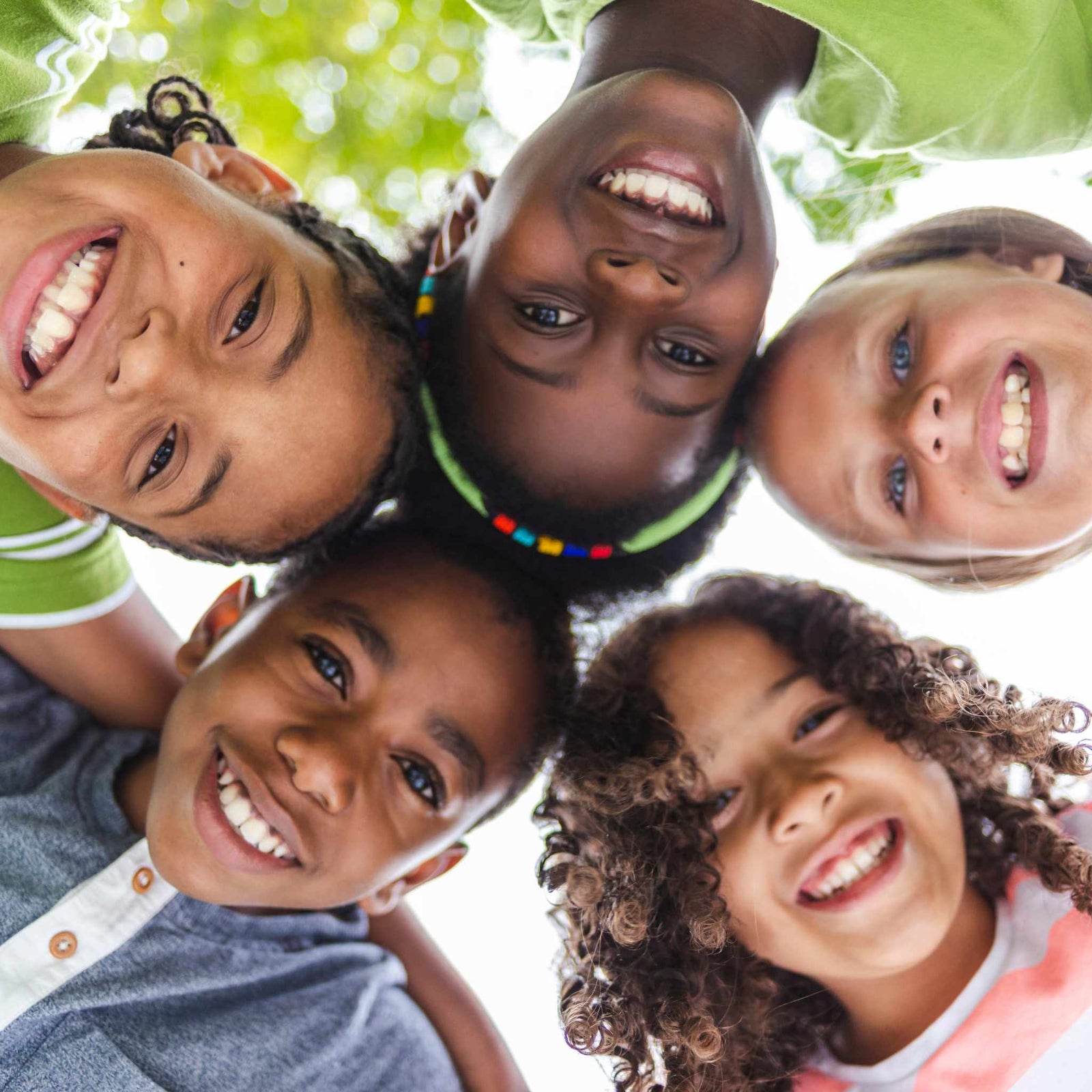 kids huddled in a circle, smiling