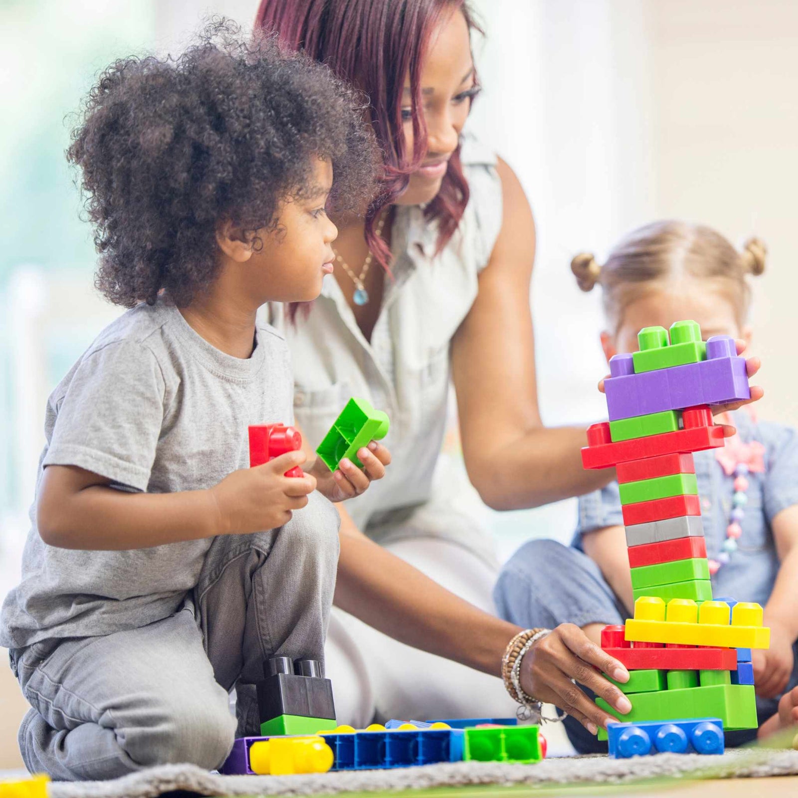 adult and kids playing with building block toys