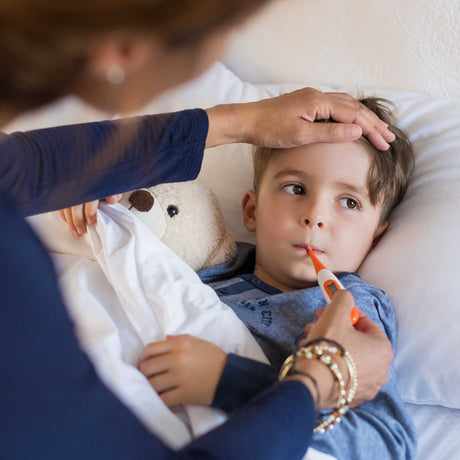 child getting temperature taken with thermometer