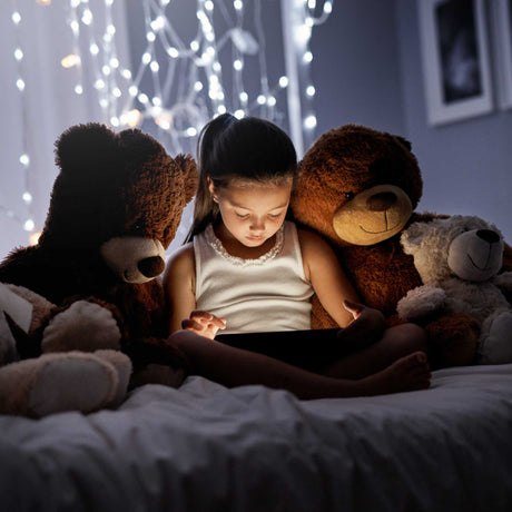 child watching a tablet in the bed