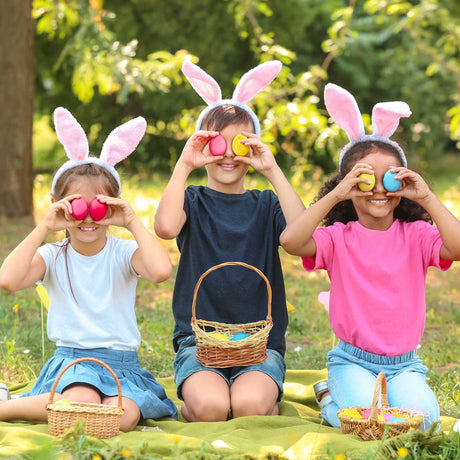 kids outside with bunny ears and colorful eggs