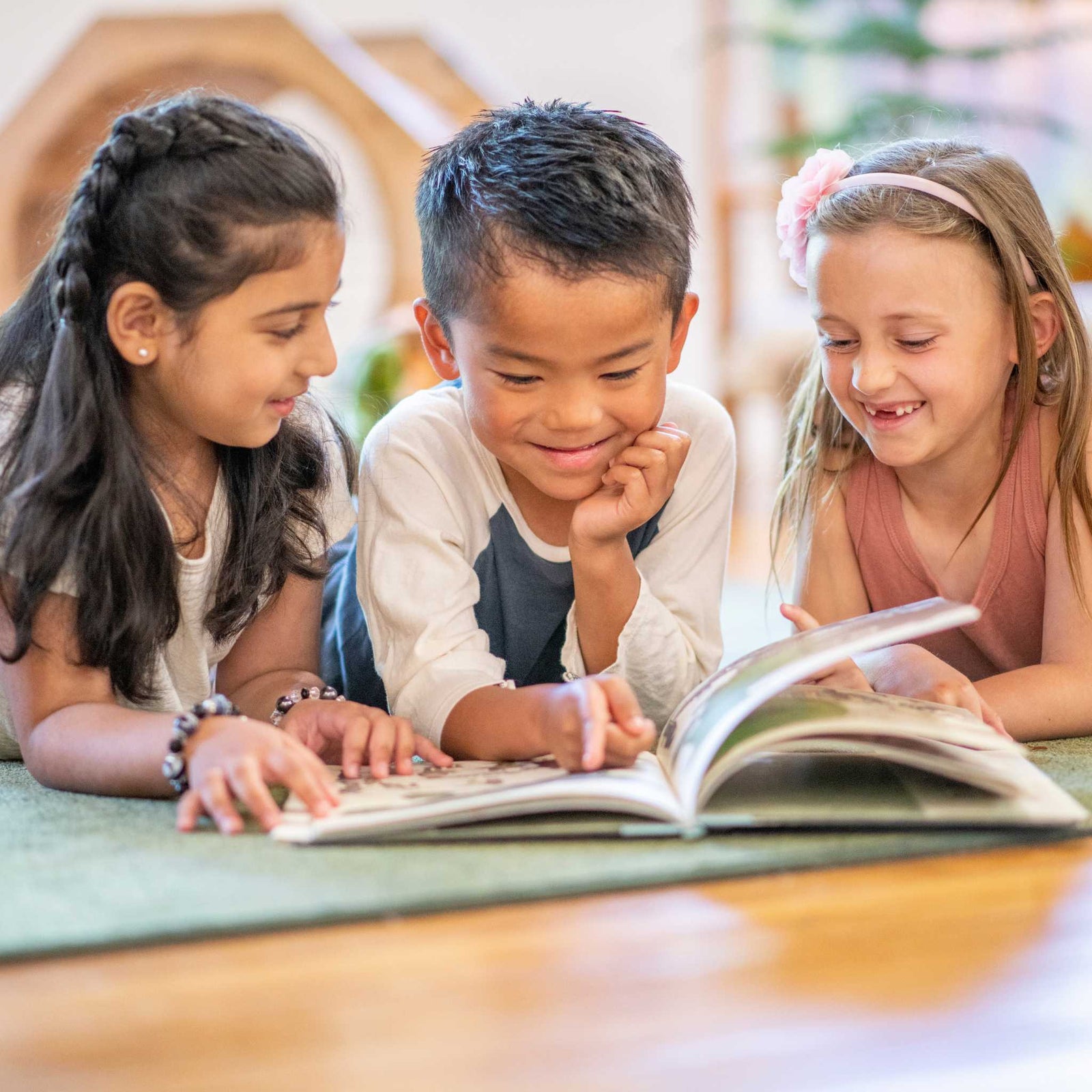 three kids reading a book together