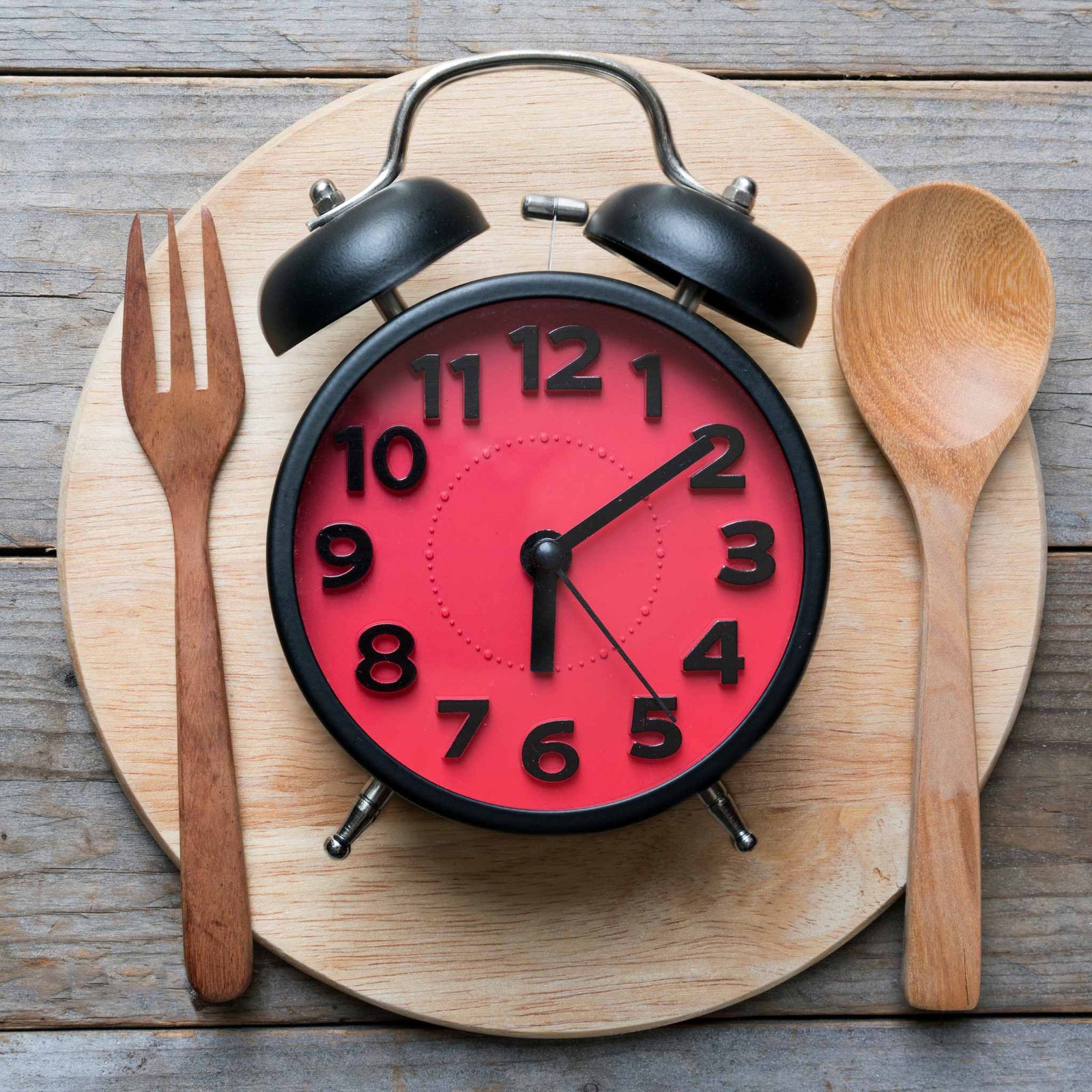 analog clock with fork and spoon next to it