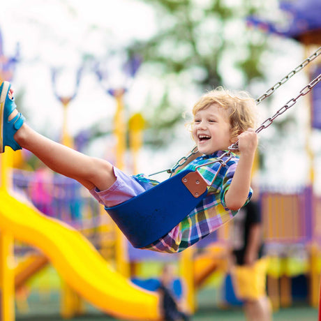 kid swinging on swing at playground