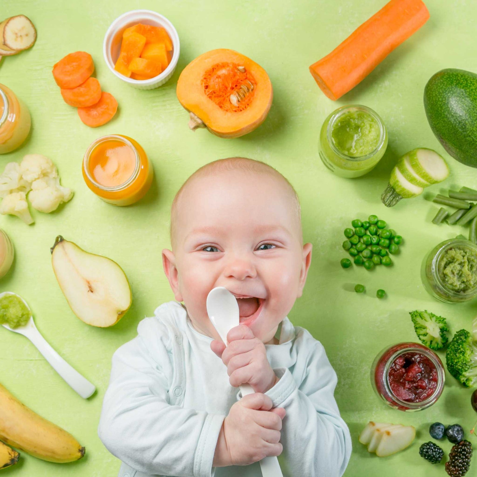 baby smiling in front of fruits and vegetables