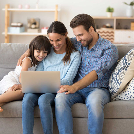 family on the couch looking at laptop