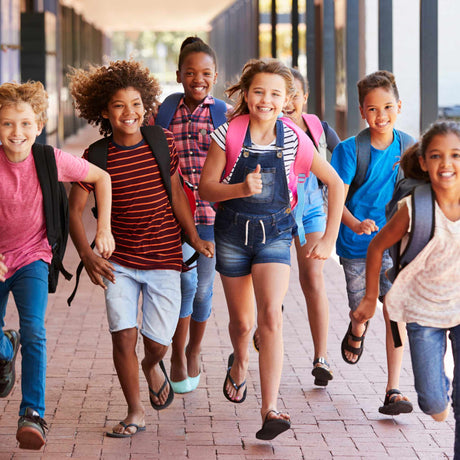 kids laughing and walking down the school hallway
