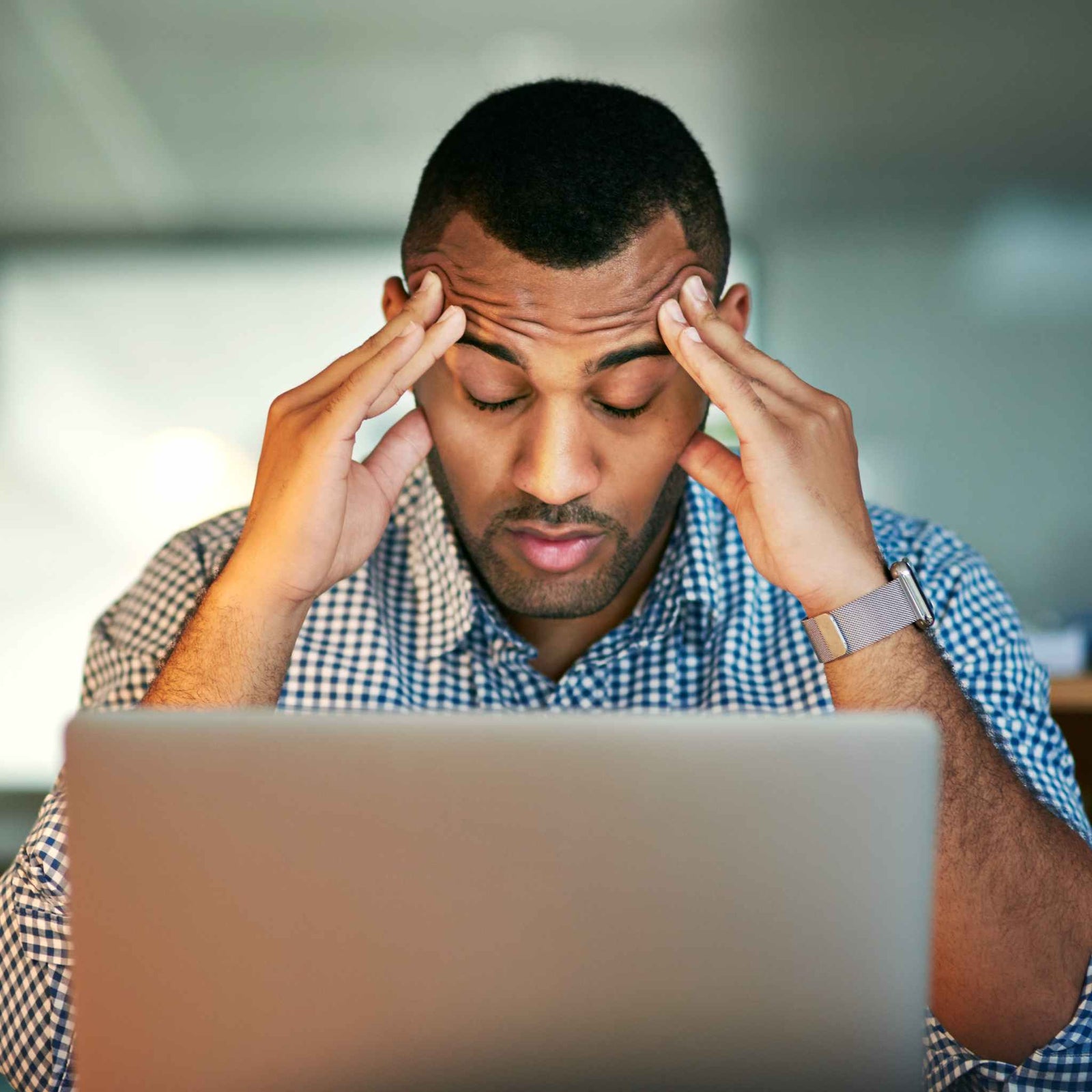 man working on laptop, looking stressed