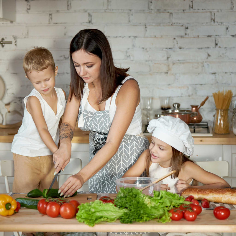 mom and kids cutting vegetables in the kitchen