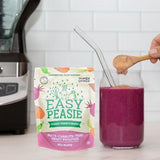 Easy Peasie Veggie Powder Red Blend powder being added to a red smoothie in glass jar