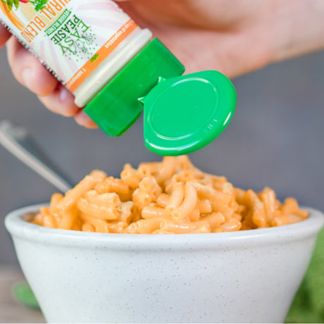 Easy Peasie Original Blend veggie powder being sprinkled on mac and cheese