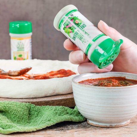 Easy Peasie Green veggie blend being sprinkled into pizza sauce